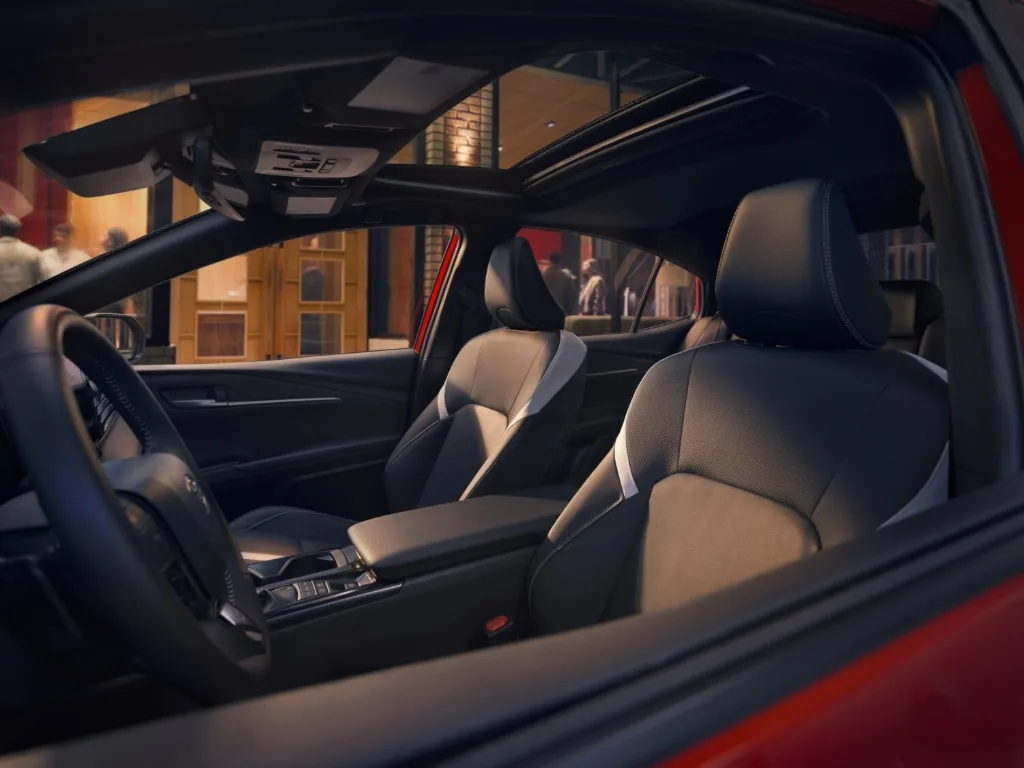 2025 Toyota Camry interior cockpit showing front sport seats and panoramic moonroof
